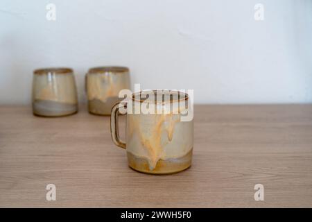 Handmade glazed ceramic mugs on wooden counter. High quality photo Stock Photo
