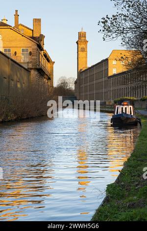 The Italianate tower of New Mill, Saltaire, reflects in the waters of the Leeds-Liverpool Canal, near Bradford, West Yorkshire Stock Photo