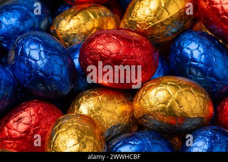 Chocolate easter eggs in colorful tinfoil close up full frame as background Stock Photo