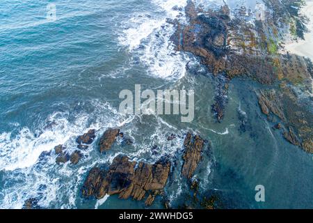 Aerial drone top down view bird eye view of sea waves breaking on rocks Stock Photo