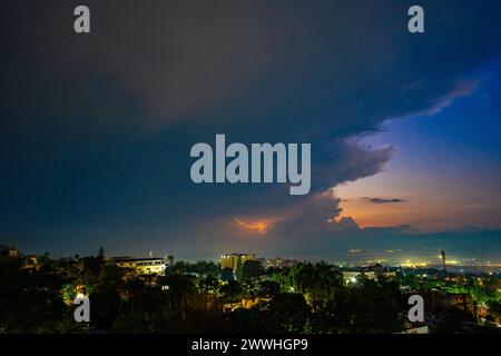 Lightning bolt falling over the city of Port-au-Prince, Haiti with dramatic clouds on one side and a colorful sunset on the other Stock Photo