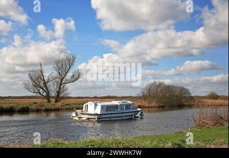 A leisurely cruise on the River Bure on the Norfolk Broads by St Benet's Abbey in the direction of Horning, Norfolk, England, United Kingdom. Stock Photo