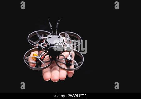 woman holds a racing drone in her hands, showing it to the camera on her palm. Close-up of a hobby toy A woman holds a r woman holds a racing drone in Stock Photo