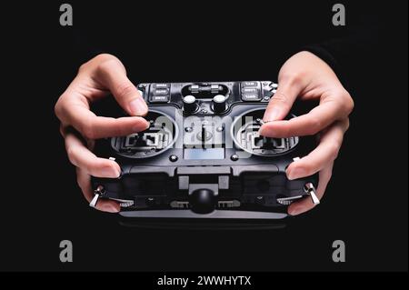 Remote control of FPV racing drone on black background in female hands, close-up Remote control of FPV racing drone on b Remote control of FPV racing Stock Photo