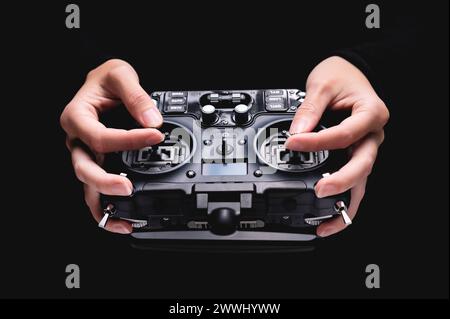 Remote control of FPV racing drone on black background in female hands, close-up Remote control of FPV racing drone on b Remote control of FPV racing Stock Photo
