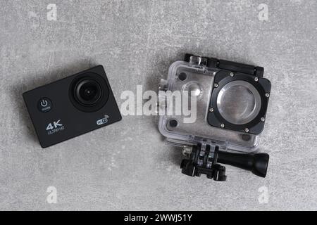4K action camera on concrete background and waterproof case Stock Photo