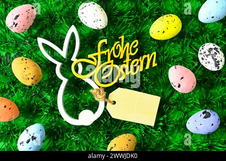 Osterhasenfigur und bunte Ostereier mit Schriftzug Frohe Ostern *** Easter bunny figurine and colorful Easter eggs with the words Happy Easter Stock Photo