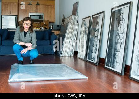 Female artist with her artwork Peekskill, New York, USA. Female artist, Melinda Hunt, showing the artwork on her Hart Island Project, while giving an interview inside her studio. MRYES Peekskill The HArt Island Project New York United States of America Copyright: xGuidoxKoppesx Stock Photo