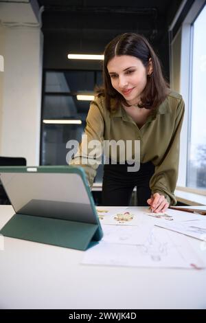 Fashion designer using modern tablet and drawing sketches Stock Photo