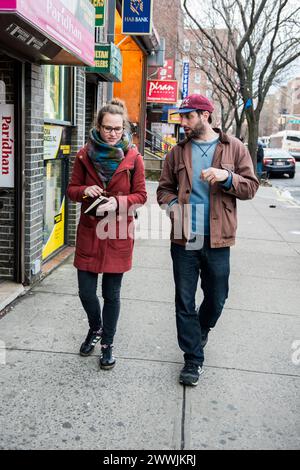 Man and woman Bronx, New York City, New York, USA. Street Portrait of a Young Asult Male Wandering the Urban Streets with a female journalsit. MRYES New York City Roosevelt Avenue, Queens New York United States of America Copyright: xGuidoxKoppesx Stock Photo