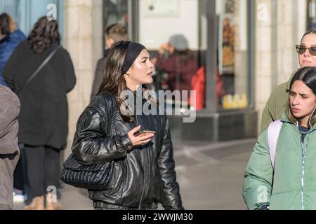 Street portrait of young happy stylish woman in black with mobile phone in hand. Dublin. Ireland. Stock Photo