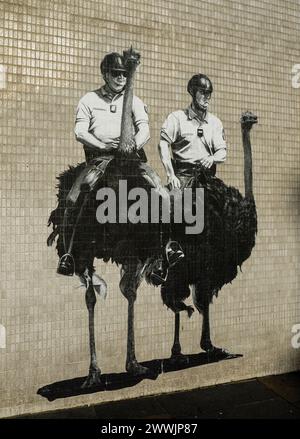 Paste-up street art of two mounted police officers riding ostriches by Murmure Street on Broad Street, Aberdeen, Aberdeenshire, Scotland, UK Stock Photo