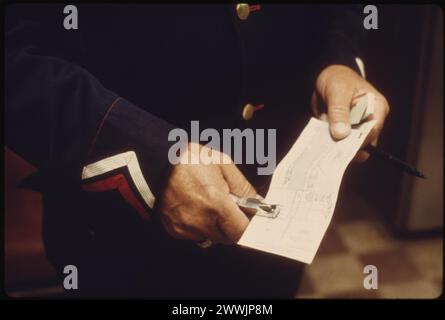 Train Conductor at Dodge City, Kansas, punches a ticket for a passenger on an eastbound Southwest Limited, June 1974 Stock Photo