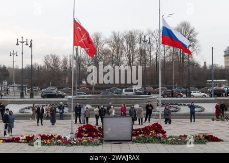 St. Petersburg, Russia. 24th Mar, 2024. People stand at the makeshift memorial, with lowered flags as they mourn for the victims of the terrorist attack at the 'Crocus City Hall' concert venue in the Moscow region. In Russia, March 24 is a national day of mourning for the victims of the terrorist attack. (Photo by Andrei Bok/SOPA Images/Sipa USA) Credit: Sipa USA/Alamy Live News Stock Photo