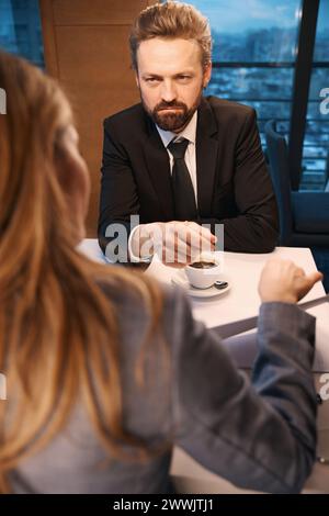 Businessman communicates over a cup of coffee with elegant woman Stock Photo
