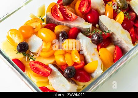 cod with potatoes and cherry tomatoes. ready in the pan to be baked Stock Photo