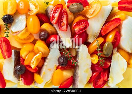 cod with potatoes and cherry tomatoes. ready in the pan to be baked Stock Photo