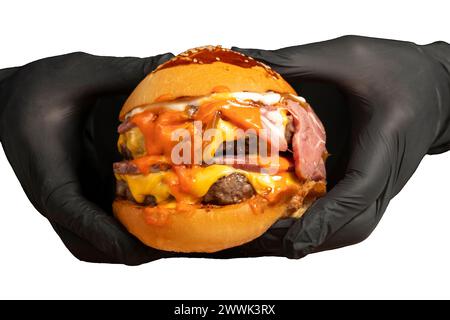 Double Hamburger isolated on white background. With Cheddar cheese, caramelized onions, Roast beef and special sauce. He is holding a burger with two Stock Photo