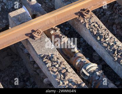 Pipe damaged by tamper packing ballast under sleepers that may have contributed to the sink-hole which caused the train accident at Grange Over Sands Stock Photo