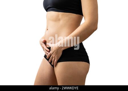 Description: View of the midsection of an unrecognizable woman in the first months of pregnancy gently holding her belly. Pregnancy first trimester - Stock Photo