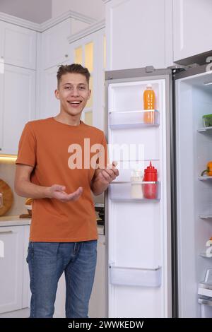 Smiling food blogger explaining something in kitchen Stock Photo