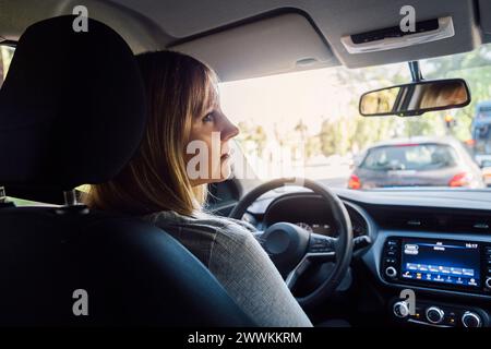 Woman in a car looking thoughtfully. Interior view. Stock Photo