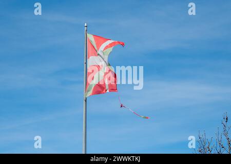 Ikurriña, the flag of the Basque Country damaged by the weather in the fishing and tourist town of Pasaia in the Province of Guipúzcoa in March 2024. Stock Photo
