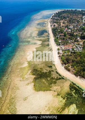 Aerial view of a reef table and coral reef off a tiny tropical island ...