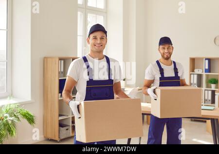 Smiling Movers with Cardboard Boxes during Relocation Stock Photo