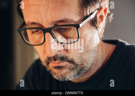 Overthinking or analysis paralysis, distraught anxious and depressive male with eyeglasses thinking, mental health concept, selective focus Stock Photo