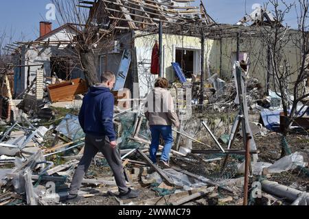 Local residents walking at the backyard private house that was destroyed by the Russian shelling in Zaporizhzhia. Russia launched another large-scale drone and missile attack against Ukrainian cities overnight on March 22, targeting Kharkiv, Zaporizhzhia, and Kryvyi Rih, primarily aiming at the energy infrastructure. Attacks were also reported in Khmelnytskyi, Odesa, Mykolaiv, Vinnytsia, Kirovohrad, Lviv, Sumy, Poltava, and Ivano-Frankivsk oblasts. Russia launched 60 Shahed-type drones and almost 90 missiles of various types against Ukraine in the overnight strike, President Volodymyr Zelensky Stock Photo