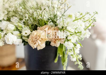 White, green and pink floral arrangement in black pot Stock Photo