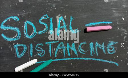 "Social Distancing" text on a black and crayon background Stock Photo