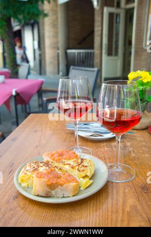 Two glasses of rose wine with tapa of Spanish omelet and tomato sauce in a terrace. Madrid, Spain. Stock Photo