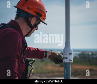 Daniel Jacobson, 325th Communications Squadron radio frequency transmissions technician, installs a bolt onto a radio tower at Tyndall Air Force Base, Florida, Feb. 1, 2024. The Cognitive Radio Frequency Systems enable the 325th CS to proactively detect and deter radio interference threats in real-time.  Air Force Stock Photo