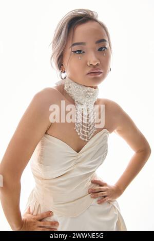 confident asian young bride in elegant  necklace and dress posing on white background Stock Photo