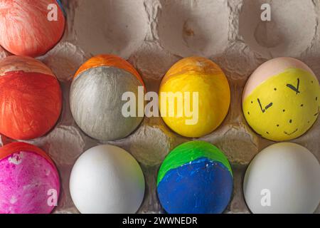 Easter eggs painted in bright colors in a cardboard box. Happy Easter concept. Close-up. Stock Photo