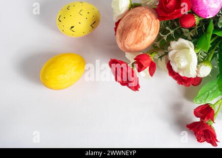 Easter eggs and flowers on a white background. Happy Easter. Top view Stock Photo