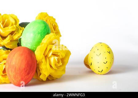 Easter eggs and yellow roses isolated on white background with copy space. Happy Easter Stock Photo