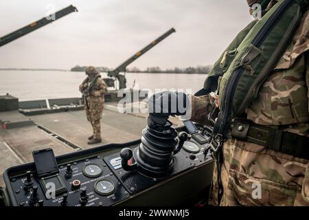 Photo Description:  A German soldier navigates an amphibious rig during an exercise, in Poland on March 2, 2024.  Exercise Background:  During Exercise Dragon-24 (DR-24) in Poland, NATO will test the Polish Armed Forces' response to potential crises, involving around 20,000 soldiers and 3,500 units of equipment from 9 NATO countries. The participants include: Poland; France; Germany; Lithuania;  Slovenia; Spain; Türkiye; United Kingdom and USA. The exercise will evaluate their ability to execute combat tasks across various domains, including land, air, sea, and cyberspace. It will include elem Stock Photo