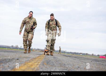 U.S. Air Force Tech. Sgt. Sarah Zaragoza, 603rd Air Operations Center airspace manager, and U.S. Air Force Staff Sgt. Caz Cusick, 1st Combat Communications Squadron radio and weather systems supervisor, measure the distance between landing zone marking panels at Chièvres Air Base, Belgium, Feb. 13, 2024. A combined team of air traffic controllers, airfield operations officers, radar airfield weather systems technicians and airfield managers earned their landing zone safety officer certification on Feb. 11 – 15, 2024. This special experience identifier allows them to perform the LZSO function i Stock Photo