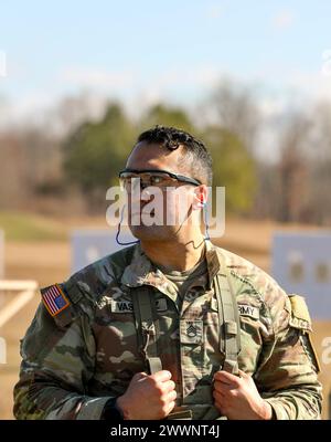 Tennessee Army National Guardsman Staff Sgt. Daniel Vasquez, from the 30th Troop Command, waits for others to adjust their close combat optics at the zero range during the Tennessee State Best Warrior Competition in Tullahoma, Feb. 23, 2024. All competitors zeroed their M-4 weapons prior to continuing with a series of battle stations.  Army National Guard Stock Photo