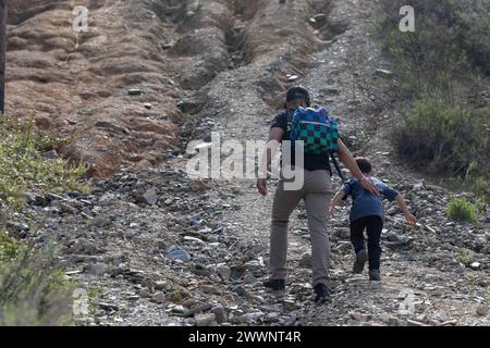 A veteran of 2nd Battalion, 1st Marine Regiment, 1st Marine Division, hikes with his son up to the Camp Horno memorial crosses as part of a reunion hike for the 20th anniversary of Operation Vigilant Resolve, also known as the first Battle of Fallujah, at Marine Corps Base Camp Pendleton, California, Feb. 29, 2024. The hike brought together approximately 150 veteran and active-duty Marines and Sailors who served with 2nd Bn., 1st Marines, during Operation Vigilant Resolve in 2004.  Marine Corps Stock Photo