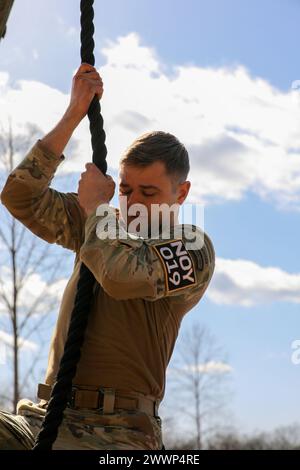 Tennessee Army National Guardsman Staff Sgt. William Lukens, from the 278th Armored Cavalry Regiment, climbs the rope during the air assault obstacle, tough one, at the Tennessee State Best Warrior Competition, in Tullahoma, Feb. 24, 2024. The tough one is the first of nine events throughout the course.  Army National Guard Stock Photo