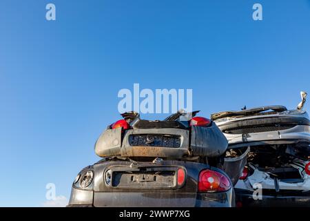 Stacked cars at a junkyard in the South-Holland village of Lisse in the Netherlands. On a blue sky. Stock Photo