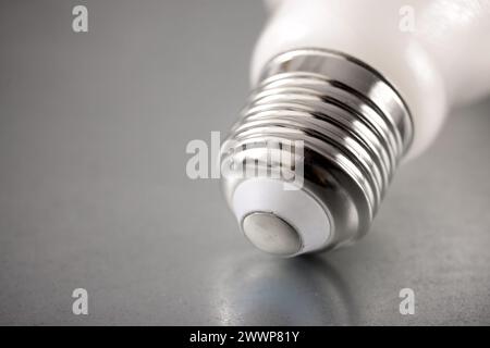 Close up of an energy-saving light bulb socket on a metal surface Stock Photo