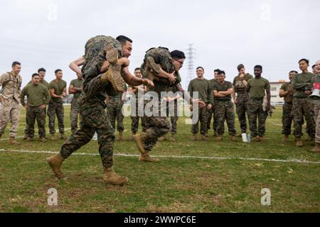 U.S. Marines Marine Wing Support Squadron (MWSS) 172 and Marine Aviation Logistics Squadron (MALS) 36 conduct buddy carries during a field meet at Camp Foster, Okinawa, Japan, Feb. 9, 2024. Marines with Marine Wing Headquarters Squadron 1, MWSS-172, and MALS-36 held the field meet to foster a sense of comradery, healthy competition, and esprit de corps between the three squadrons.  Marine Corps Stock Photo