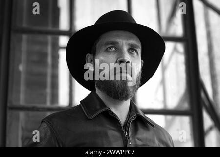 Stylish man with beard wearing fedora hat . Bearded man wearing black hat . Stock Photo