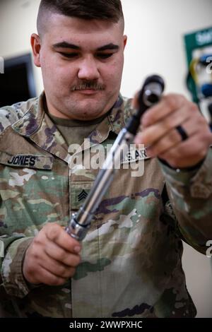 Oklahoma Army National Guardsman Sgt. Daniel Jones, a wheeled vehicle mechanic assigned to Golf Company, 700th Brigade Support Battalion, 45th Infantry Brigade Combat Team, takes on a mechanical challenge during the Mechanic of the Year competition held at the Combined Support Maintenance Shop in Norman, Oklahoma, Feb. 7, 2024. Jones won the title of individual Mechanic of the Year, after ten teams gathered to put their mechanic skills to the test in the third annual competition, working to beat out the competition while also getting to network amongst fellow competitors. (Oklahoma National Gu Stock Photo