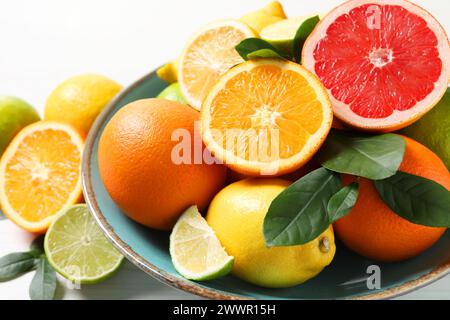 Different cut and whole citrus fruits on white table, closeup Stock Photo